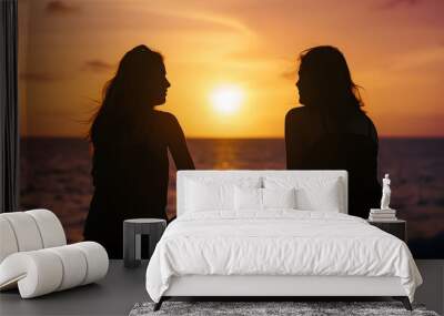 Silhouette of two female friends enjoying a conversation while sitting and watching the sunset on a sea beach Back view : Generative AI Wall mural