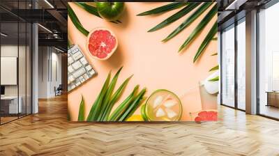 Summer work freelancing combining work and leisure vacation concept Office flatlay with keyboard laptop tablet mouse notepad palm leaves tropical fruits  and cocktail banner header top : Generative AI Wall mural