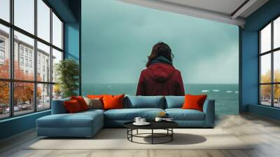 Young woman feeling lonely and sad looking at the sea on a gloomy day : Generative AI Wall mural