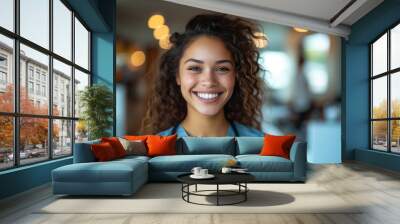 Portrait of a young happy latina woman doctor smiling looking at the camera in a blue scrub and stethoscope. Wall mural