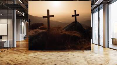 Two crosses are on a rocky hillside, with the sun setting behind them Wall mural