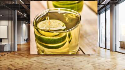 Alcohol drink. On wooden boards are two glasses with alcohol green transparent drink. Drink number hundred and three cocktail green tea with lime. Country life. Light background. Wall mural