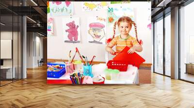 Child with scissors cut  paper  in playroom. Wall mural