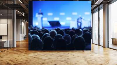 Business and entrepreneurship symposium. Speaker giving a talk at business meeting. Audience in the conference hall. Rear view of unrecognized participant in audience. Wall mural