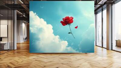 Blue background with a cloudy sky featuring a single rose petal falling soft edges and a vibrant splash of color Wall mural