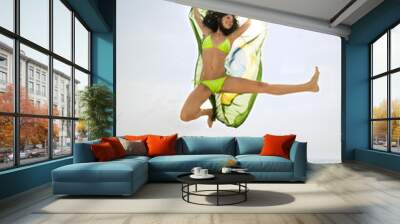 Young attractive girl on beach jumping with Brazil flag Wall mural