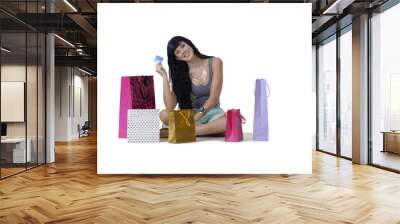 Young attractive shopper girl showing off her bank card Wall mural