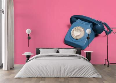 blue vintage antique rotary phone on a pink background with copy space and room for text with a right side composition Wall mural