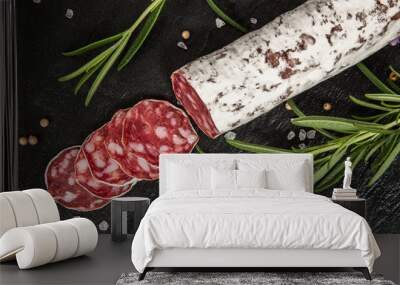 Salami on dark background Wall mural