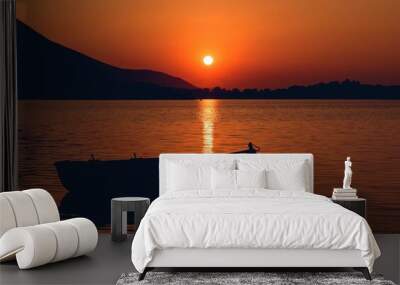 Beautiful shot of a silhouette of a boat at sunset Wall mural