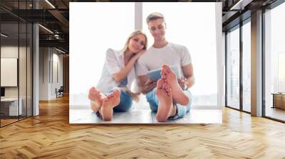 Beautiful young couple with gadget Wall mural