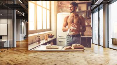 Sexy young man in kitchen Wall mural