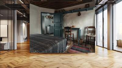 Traditional interior of old bedroom with handmade wooden furniture and traditional  folk ornament textile in historic country village house Wall mural