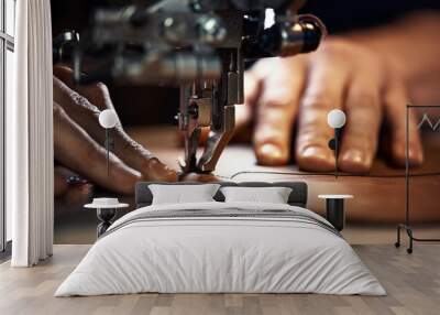 A sewing machine foot with the hands of a master close-up, a tailor makes a seam on a piece of leather on a sewing machine, the concept of sewing leather products Wall mural