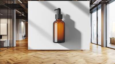 Amber glass bottle with black pump dispenser for hair care products in a minimalist design setting on a clean white background Wall mural