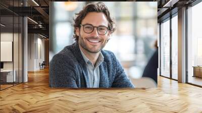 Confident and smiling man in casual attire enjoying a moment at a modern café with a blurred background Wall mural