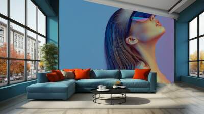 Cool stylish girl with a fashionable hairstyle and stylish glasses with a large glass poses on a bright neon background. Wall mural