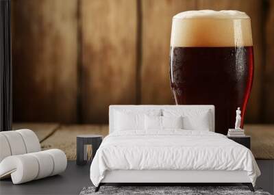 Frosty pint glass filled with rich dark beer on rustic wooden table background Wall mural