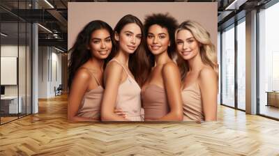 Half-length studio portrait of four cheerful young diverse multiethnic women. Female models smiling at camera while posing together. Diversity, beauty, friendship concept. Beige monochrome background. Wall mural