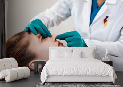 Lady with plaster on nose, doctor examining patients face after plastic surgery Wall mural