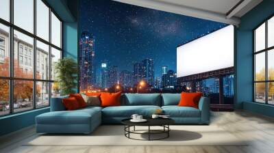 Large blank billboard overlooking a bustling cityscape at night with bright lights illuminating the urban skyline and busy highway Wall mural