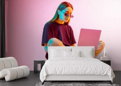 Modern Girl with laptop, tablet computer. Free creativity. A young blogger makes a Home office. Colored Neon light and background. Wall mural