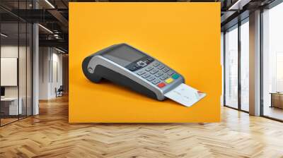 Payment by credit card. Terminal on yellow background copy space Wall mural