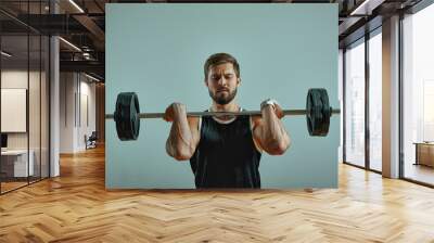 Portrait of super fit muscular young man working out in gym with barbell on gray background, copyspace. Wall mural