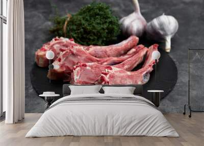 Raw lamb chops with garlic, herbs on black ceramic plate over white stone gray table. Top view. With copy space Wall mural