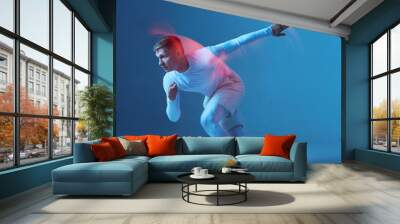 Sprinter start. Male strong muscular athlete starts running on blue background. Wall mural