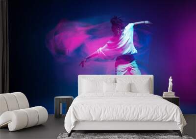 Stylish dancing modern girl moving in colorful neon studio light. Long exposure. Copy space Wall mural