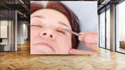 Surgeon applies a bandage to the female patient's eyelids after a blepharoplasty operation Wall mural