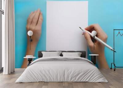 Overhead shot of female hands writing with pen over empty white sheet of paper on blue background hobby drawing art pencil art top view message note minutes list office page work Generative AI Wall mural