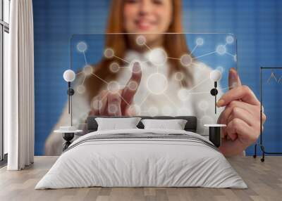 Smiling woman pressing touch screen on social network icon Wall mural