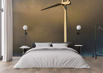 Eerie looking wind turbine in early morning light against dramatic cloud backdrop Wall mural