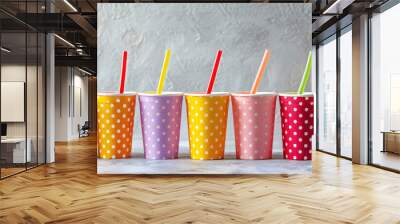 Colorful cardboard cups with straws in line isolated on grey background texture, for party birthday celebration Wall mural