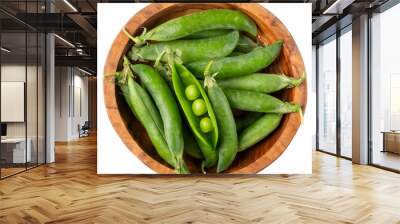 Green pea pods in wooden bowl isolated on white. Top view. Wall mural