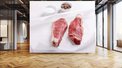 Raw beef striploin steak. Two strip loin steaks on white table. Wall mural