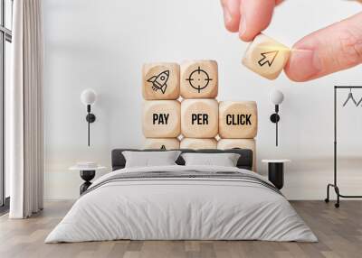 Concept Pay per click or PPC. Person stacks wooden cubes from text and icons. Wall mural