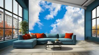 Thick cloudy sky with blue gaps. Wall mural