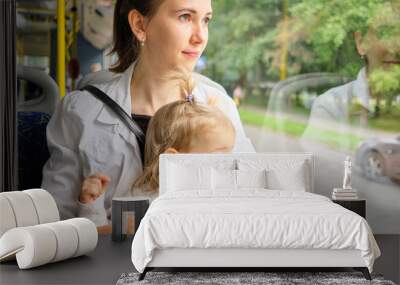 toddler and Mom sit on the bus seat and look out the window. Wall mural