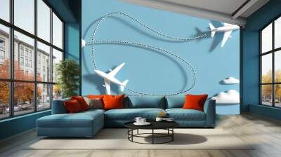 Minimalist 3D illustration featuring two white airplanes with dotted flight paths, intersecting in a looping pattern against a light blue background with fluffy clouds. Wall mural