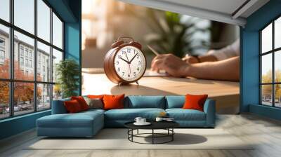 Alarm clock on table near business man working on laptop, meeting discussion people or team background, time management concept, focused on alarm clock Wall mural