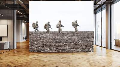 Army soldiers group on march in muddy field Wall mural