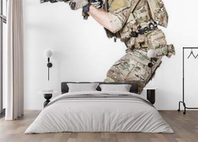 Member of US Army rangers in combat uniforms with his shirt sleeves rolled up, in helmet, eyewear and night vision goggles, ready to firing. Low readiness position. Studio shot, white background Wall mural