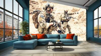 two armed us army commandos or military scouts equipped with radio headset moving forward in sands d Wall mural