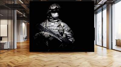 United States Armed Forces soldier in battledress with black glasses and mask on face, armed squad automatic weapon emerges from darkness. Military threat, secret stealth mission, hybrid war combatant Wall mural