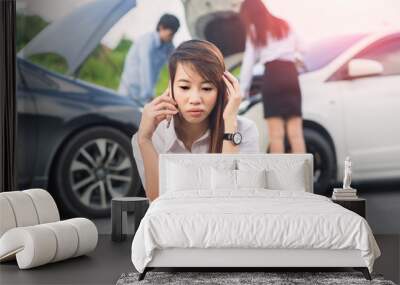 Car collision. Asian driver man and woman examining damaged automobile cars after crash accident in city Wall mural