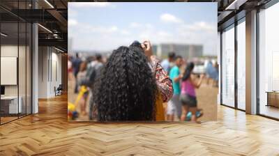 Curly Girl with a camera taking pictures in modern architecture Brasilia Brazil Desfile 7 de Setembro Parade September 7th Wall mural