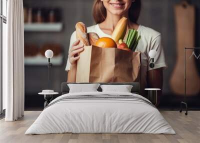 Young woman holds paper bag from supermarket with food Wall mural